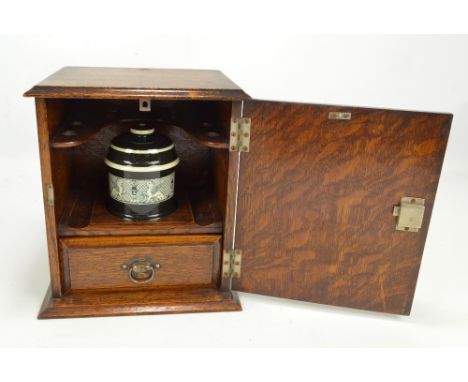 An oak smoker's cabinet with internal ceramic lidded jar and single shelf, 26.5 x 23cm.