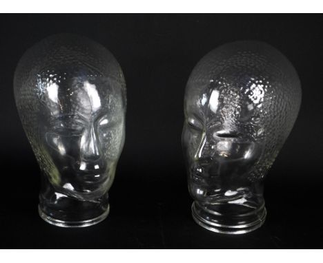 A pair of moulded glass mannequin heads with 1920s style textured hair/hats, height 26cm.