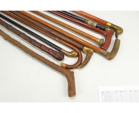 A collection of nine walking sticks and canes to include horn and antler handled examples, one with silver collar, two rustic