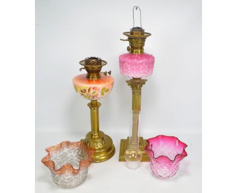 A Victorian brass Corinthian column oil lamp with opaque ruby and white glass reservoir, height 60cm including fittings, a fu