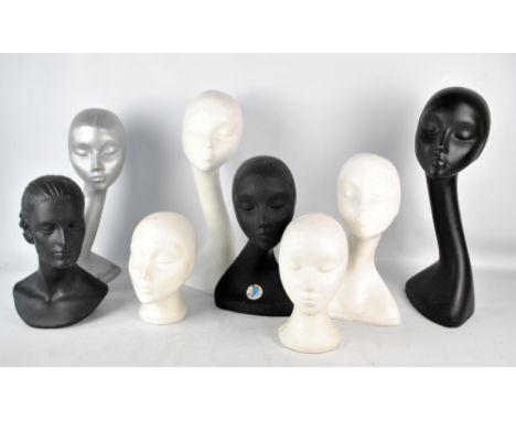 A collection of mannequin heads comprising a tall silver composite head marked Christian Dior, two black and one white compos