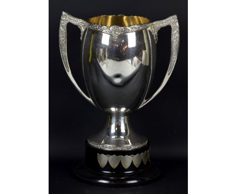 A large silver plated twin handled trophy cup with Celtic decoration, spreading circular foot and plastic stand bearing plaqu