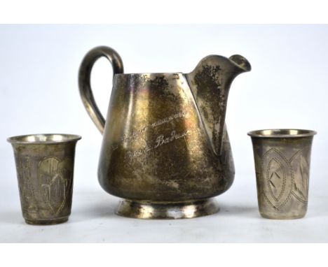 A late 19th/early 20th century Russian silver jug engraved with cottages and Art Nouveau style floral motifs to one side and 