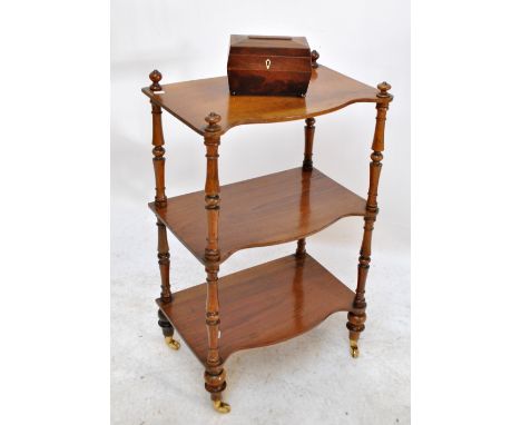 An early 20th century walnut three tier serpentine fronted whatnot with ring turned supports and castors, width 53cm, height 