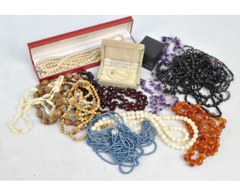 A collection of bead necklaces to include jasper, mother of pearl, Baltic amber, ruby glass, faux pearls etc.