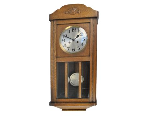 An oak cased wall clock, the silvered circular dial set with Arabic numerals, dial diameter 18cm, length approx 76cm.