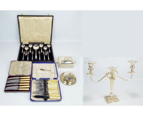 A quantity of silver plate to include a Georgian style candelabra, two butter dishes and various flatware.