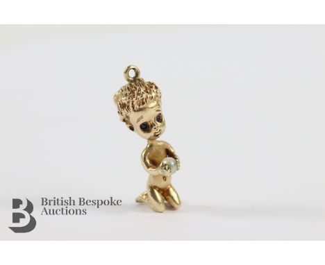 10ct gold kneeling angel pendant, sapphire eyes clutching a pearl, 29mm, approx 7.93 gms.&nbsp;
