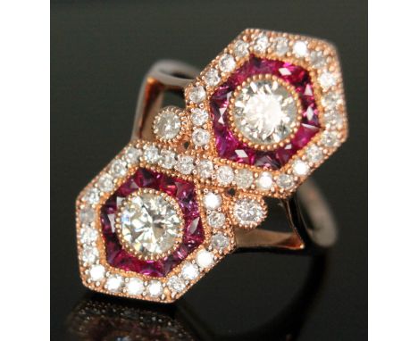A diamond and ruby cluster ring featuring two modern round brilliant cut diamonds weighing approx. 0.25 carats each surround 