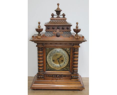 A German late 19th century walnut mantle clock of architectural form with pagoda top, finials, bobbin columns, brass and silv