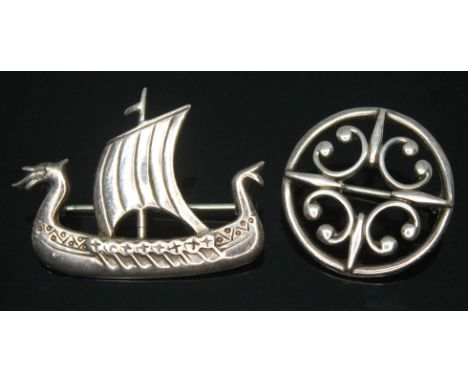 Two Scottish brooches by Ola M Gorie, one hallmarked silver formed as a Viking ship, and the other of Celtic form and marked 