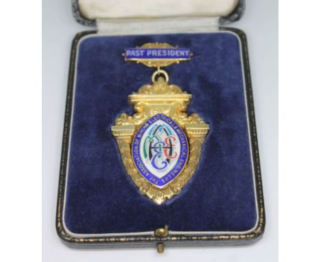 A hallmarked silver gilt medallion with central enamel cartouche inscribed THE ASSOCIATION OF MININ ELECTRICAL MECHANICAL ENG