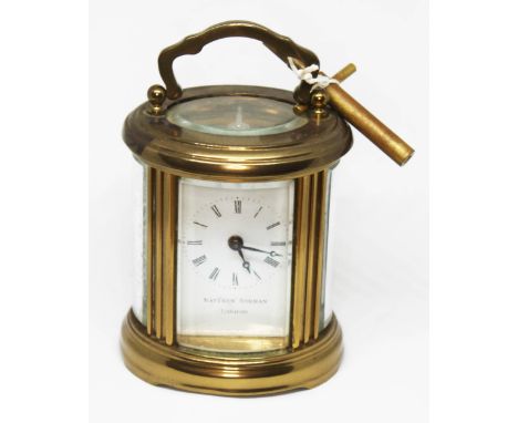 A Matthew Norman miniature brass carriage clock of oval form, height 10cm.
