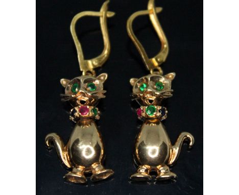 A pair of novelty earrings formed as cats with articulated head and body emerald set eyes and a collar set with emerald, sapp