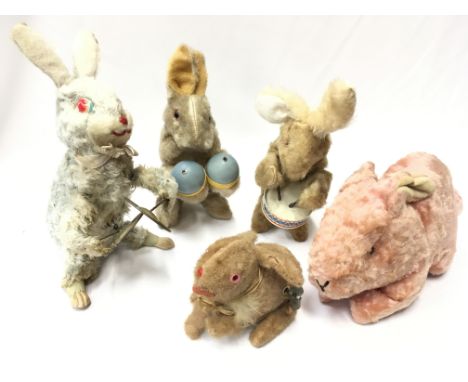 Four mechanical novelty rabbits: three playing instruments and the other with hopping motion, height of tallest approx. 20cm.