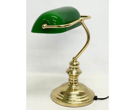 A brass desk lamp with glass shade. 