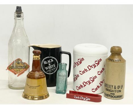 A collection of vintage breweriana. A Cork Dry Gin ice bucket with tongs, an early 20th century salt glazed beer bottle by Sh