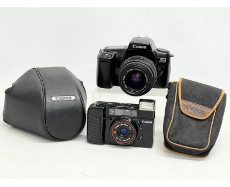 2 vintage cameras in cases. A Canon EOS 1000f. Canon Sure Shot. 