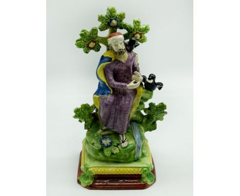 A STAFFORDSHIRE CERAMIC FIGURE DEPICTING THE PROPHET ELIJAH IN THE WILDERNESS BEING FED BY RAVENS.LATE 19TH CENTURY OR POSSIB