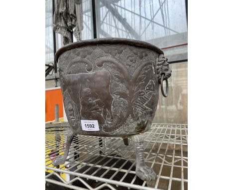 A VINTAGE ORNATE AND DECORATIVE COPPER PLANTER WITH TWIN LION HEAD HANDLES AND TRIPOD FEET 
