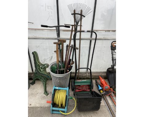 AN ASSORTMENT OF GARDEN TOOLS TO INCLUDE A LAWN MOWER, RAKES AND FORKS ETC 