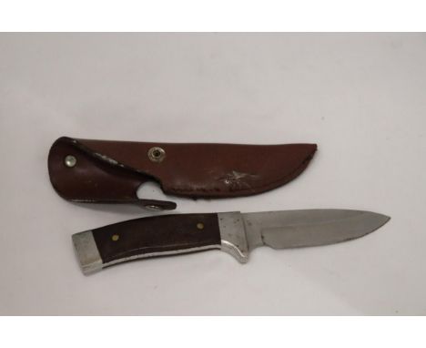 A HUNTING KNIFE IN A LEATHER SHEATH 