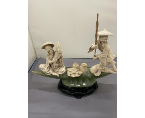 AN ORIENTAL CARVING OF FISHERMEN ON A POSSIBLY JADE BOAT, HEIGHT 20CM, WIDTH 27CM 