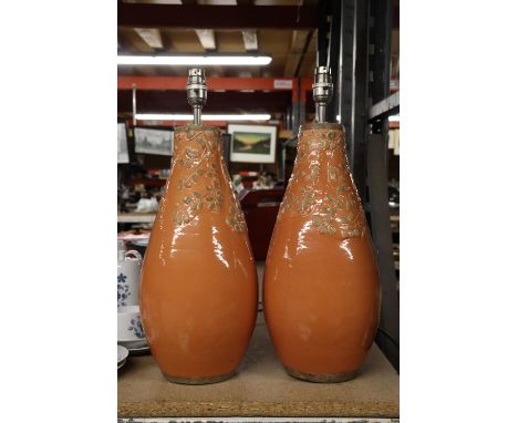 A LARGE PAIR OF STUDIO POTTERY LAMP BASES IN ORANGE WITH EMBOSSED LEAF DESIGN, HEIGHT APPROX 40CM 