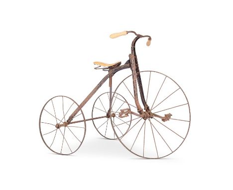 A vintage iron child's tricycle
With turned handles and leather seat, 70cm high.

Provenance:
The Property of a Lady of Title