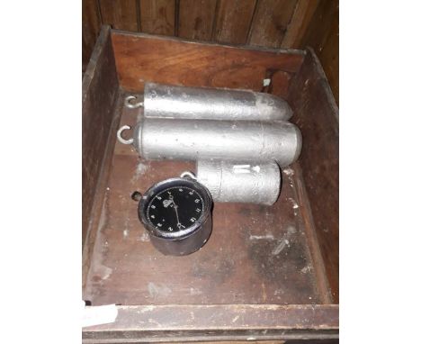 A box containing three long case clock weights and a Smiths car clock. 