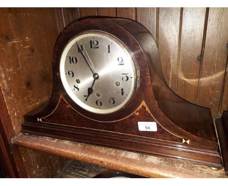 An inlaid mahogany chiming mantle clock with brass bun feet, length 50cm. 