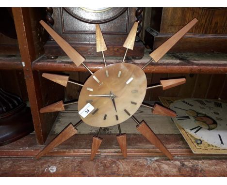 A retro imitation amber and teak sunburst clock, signed Manley, length 53cm.&nbsp;Condition - good, no damage/repair, general