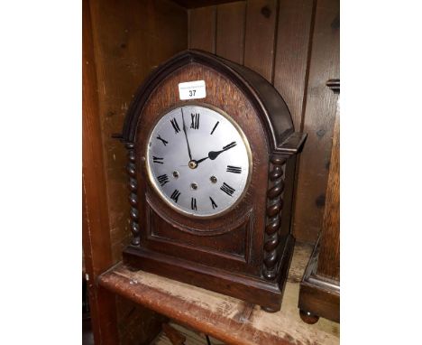 A 1920s arched oak chiming mantle clock, height 34.5cm, dial re-painted, no glass. 