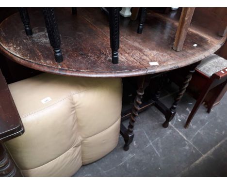 A twist oak drop leaf table and a modern leather pouffe 