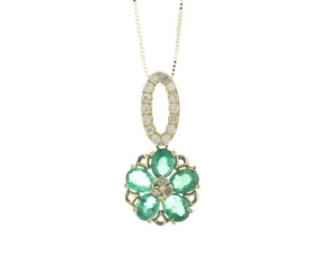 Three round brilliant cut diamonds are set in the centre of this flower cluster. Six oval emeralds create the petals of the f