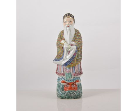 Chinese polychrome figure, of an Immortal carrying a scroll, 23cms.