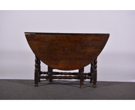 Joined oak gateleg table, oval top with two fall leaves, bobbin turned gates, the top 110 x 130cms, height 69cms.