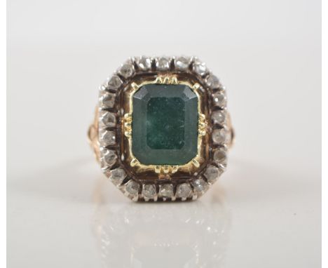 Large emerald and diamond cluster ring, rectangular step cut emerald held in a closed back setting surrounded by twenty-two o