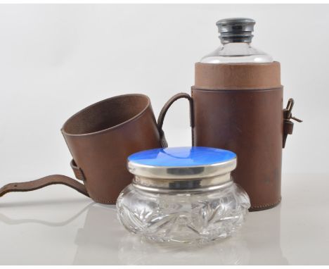 A small case containing silver backed brushes, a flask in a leather holder, three piece condiment set,and a silver top jar, (