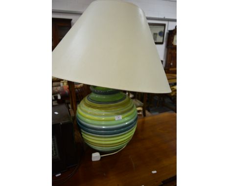 Modern pottery lamp base, spherical moulded form, green glaze, with shade, height 86cms overall.