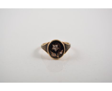 A 15 carat yellow gold mourning ring, the oval black head having a floral motif set with eight rose cut diamonds, splayed bla