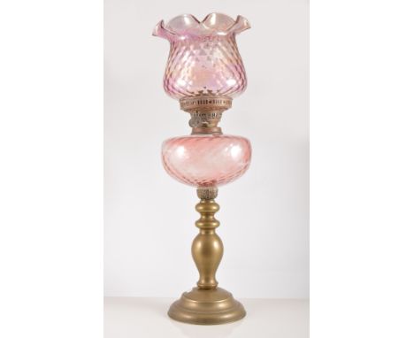 Brass oil lamp, pink tinted moulded reservoir, shade, height overall 59cm.