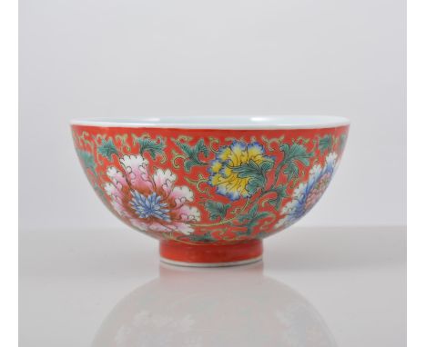 Chinese red ground bowl, decorated with stylised Chrysanthemums, the interior with peaches and blossom, printed four characte