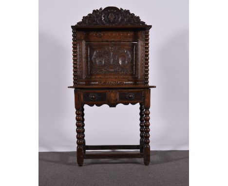 Oak side table, raised back with a cast mask and flower pediment above a shelf, bobbin turned supports, the panel with an urn