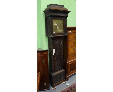 ~ A carved oak eight day longcase clock, brass dial with chapter ring signed E Harman, Workington, later carved case