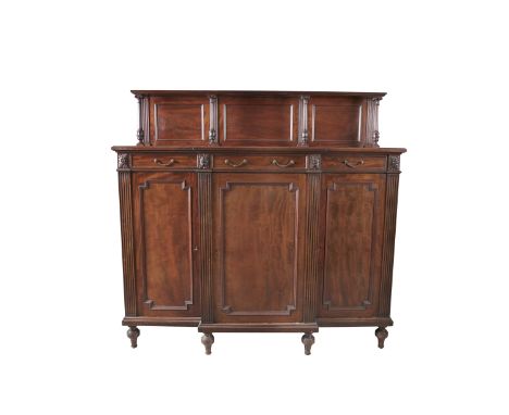 AN EDWARDIAN MAHOGANY BREAKFRONT CHIFFONIER, with raised superstructure, the top shelf supported by reeded columns above thre