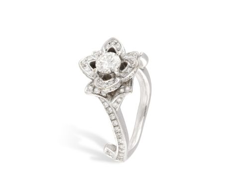 A DIAMOND DRESS RING, designed as a flower, set with a brilliant-cut diamond at the centre, to a surround of similarly-cut di