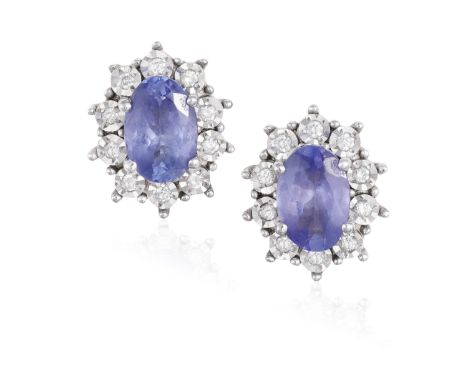 A PAIR OF TANZANITE EARSTUDS, each oval-shaped tanzanite within four claw-setting, to a surround of single-cut diamonds, moun