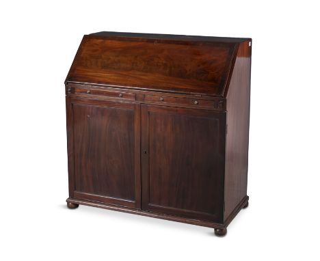 A 19TH CENTURY MAHOGANY SLOPE FRONT BUREAU, fitted interior raised above twin shallow drawers on a cupboard base, with twin f