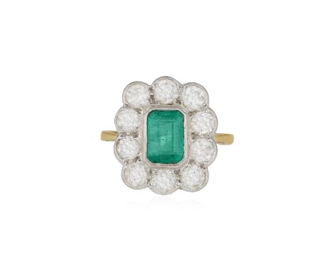 AN EMERALD AND DIAMOND CLUSTER RING, the cut-cornered rectangular-cut emerald within collet-setting, within a surround of old